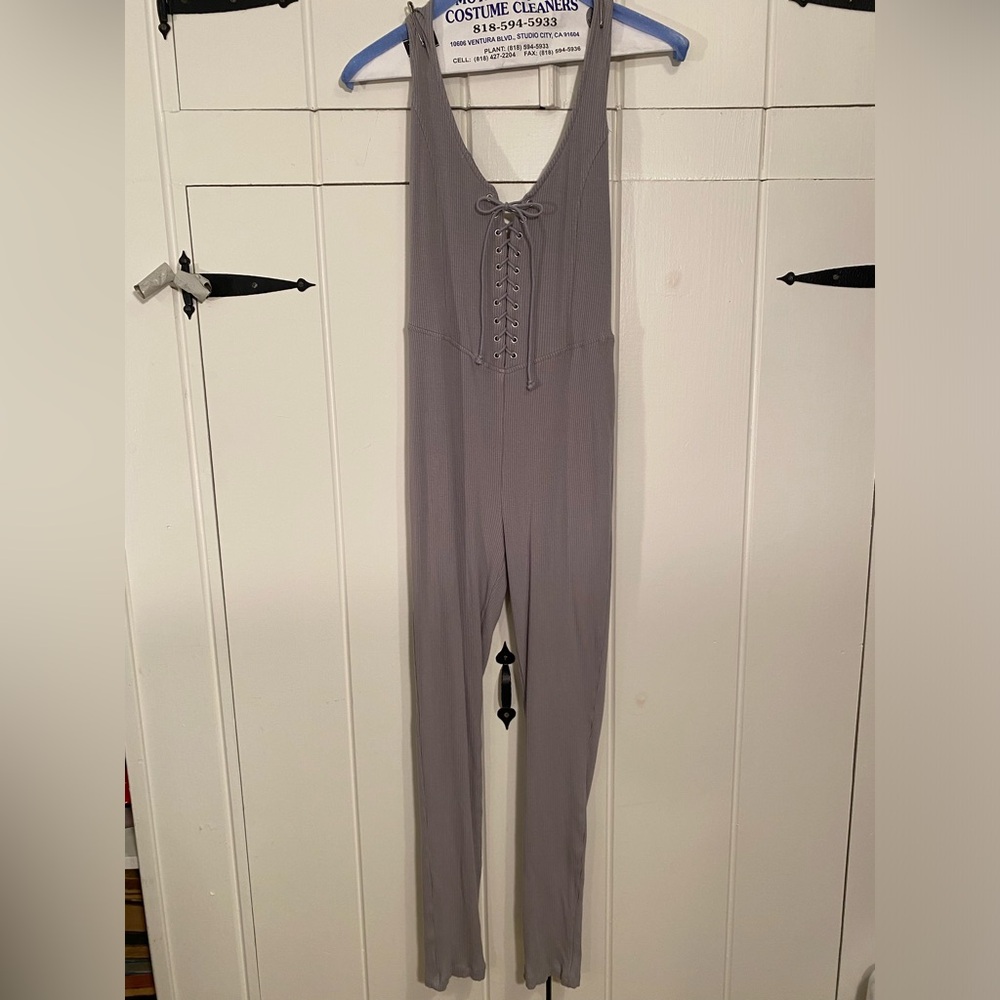 Forever 21 Knit jumpsuit featuring a halter neckline and lace up front. …